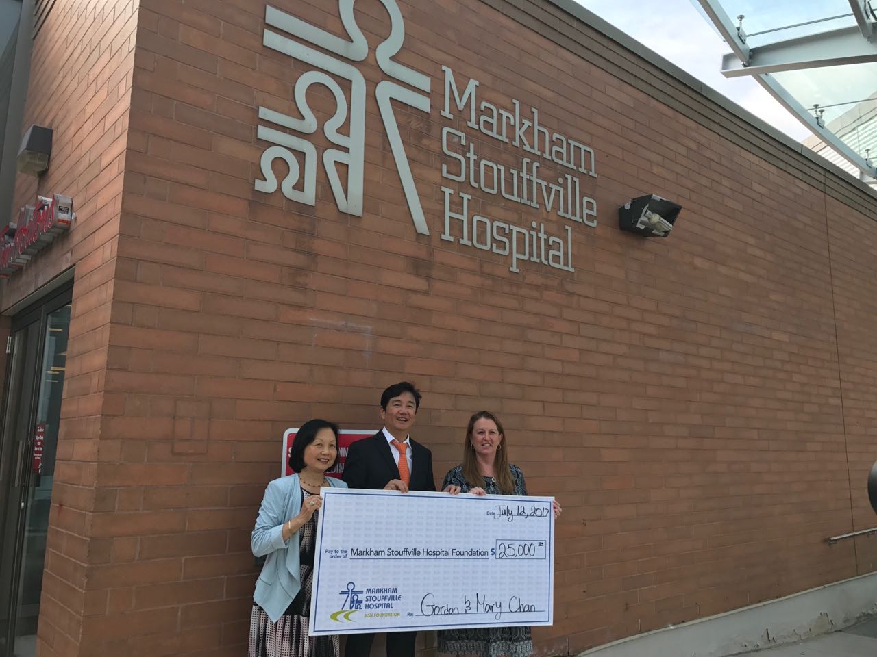 gordon and mary chan standing infront to the Markham Stoufville Hospital with a donation cheque.